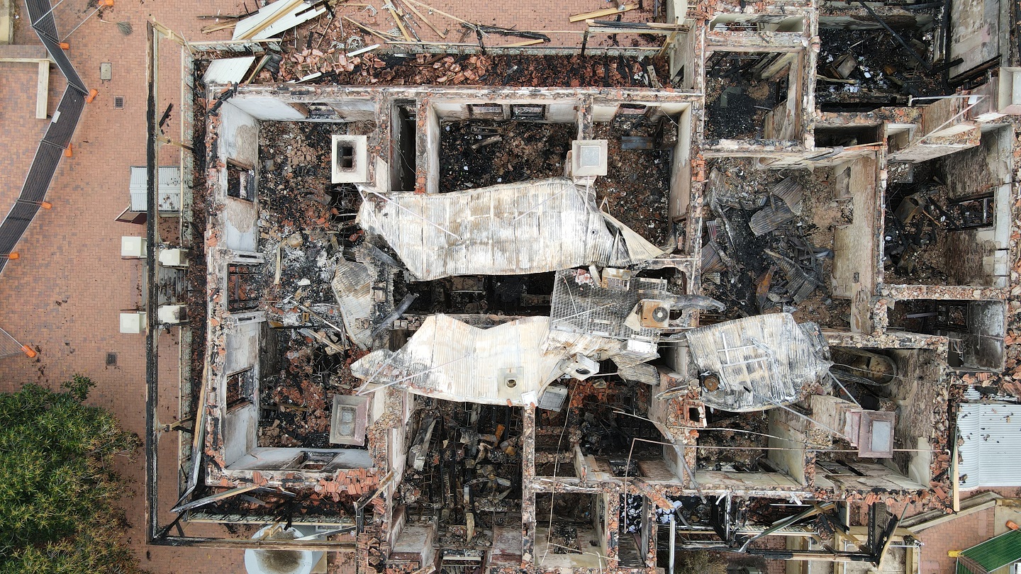 A school, that been damaged by a fire, debris and fallen infrastructure 