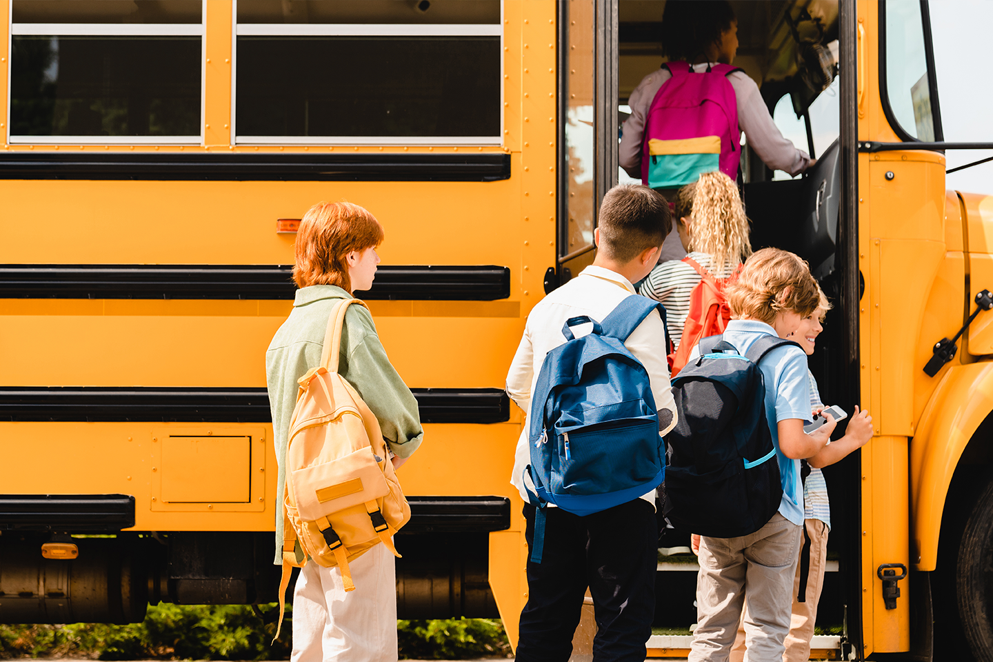 Schoolchildren kids pupils group of mixed-race classmates boarding school bus by insidecreativehouse