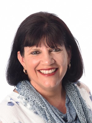 Tamra Harvey-Mardle, 2011 Primary Teacher of the Year. Tamra has a confident smile and is wearing a cerulean scarf over a white blouse with blue, water-colour-like markings.