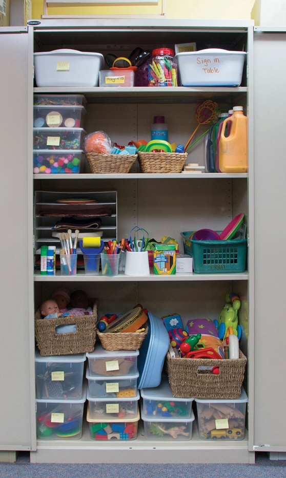 An open metal locker displaying stored equipment and supplies like toys, paint. etc