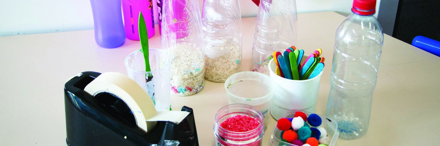 An assortment of plastic bottles containing uncooked rice and decorative items