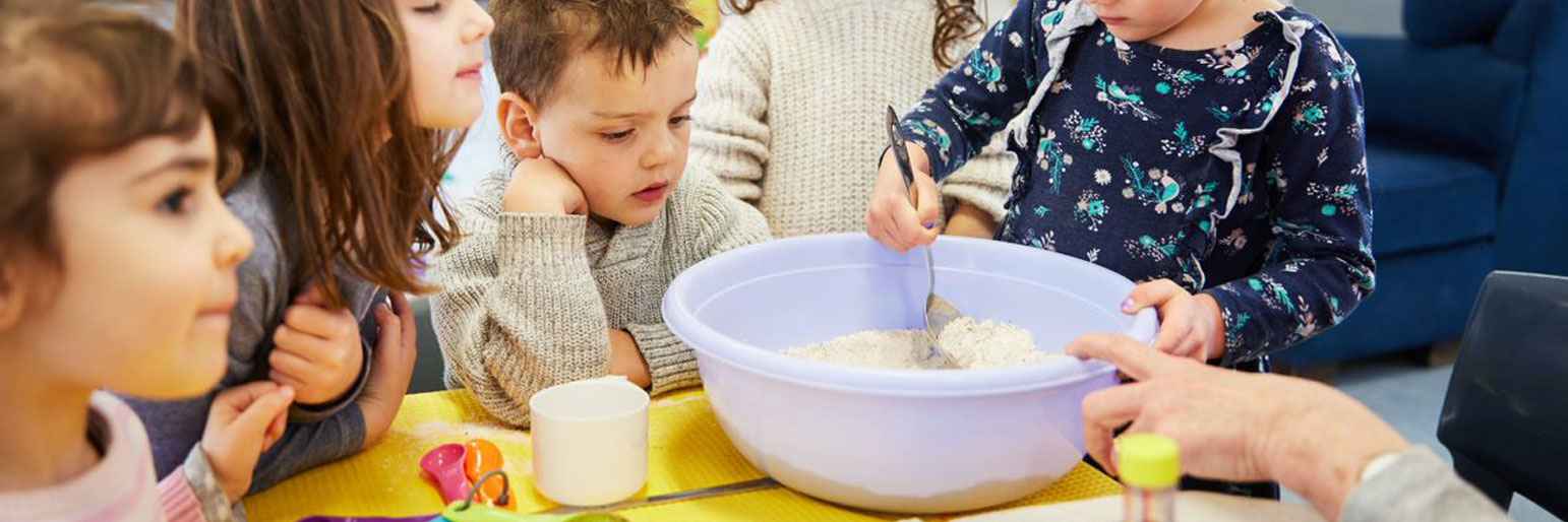 children mixing playdough ingredients in a bowl