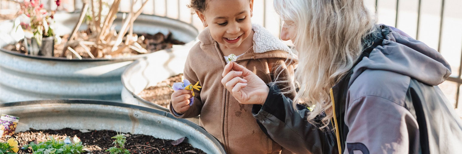 a child and adult looking at flowers together